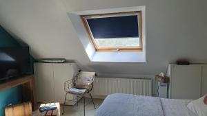a bedroom with a bed and a window and a chair at Evned Kelien in Theix