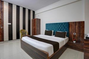 a bedroom with a large bed with a blue headboard at Hotel O Swastik Inn in Chinhat