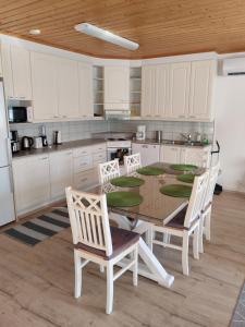 a kitchen with white cabinets and a table and chairs at Pikkurinki 28 As 2, 62300 Härmä Kauhava in Alahärmä