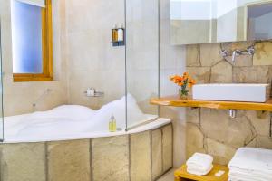 a bathroom with a tub and a sink at Galileo Boutique Hotel in San Carlos de Bariloche