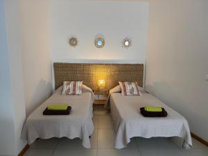 two twin beds in a room with aermottermottermottermott at Trajadinha in Vila Praia de Âncora