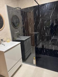 a bathroom with a white sink and a black wall at Trajadinha in Vila Praia de Âncora +30 photos