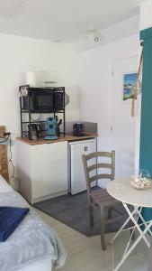 a kitchen with a table and a chair and a microwave at Evned Kelien in Theix