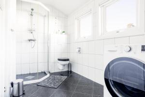 a bathroom with a shower and a toilet and a sink at Koselig leilighet strandnær opplevelse! in Grimstad +30 photos