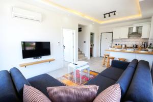 a living room with a blue couch and a kitchen at Meva Luxury Apartments in Muğla