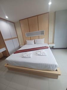 a bedroom with a large bed with white sheets at Valhalla Pattaya Hotel in Jomtien Beach