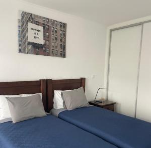 a bedroom with two beds and a sign on the wall at d Albuquerque - AL in Ponte de Sor