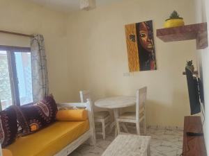 a living room with a couch and a table at Orange apartments 3 in Watamu +6 photos
