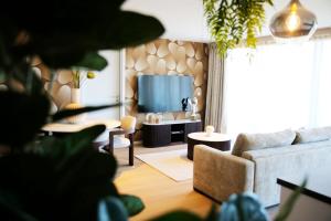 a living room with a couch and a television at Elite Suite in Liège