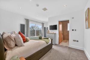 a bedroom with a large bed and a window at The Oak Nest in Otford