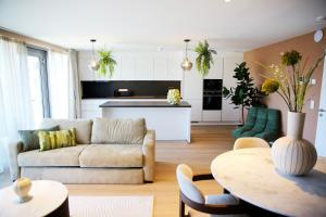 a living room with a couch and a table at Elite Suite in Liège