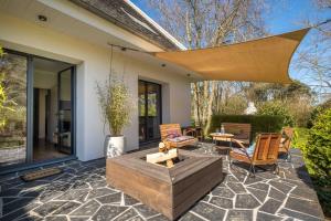 a patio with a fire pit and a table and chairs at EDEN LOCQUIREC l Flow Breathe & SPA l La Chambre d'Hôtes réinventée in Locquirec