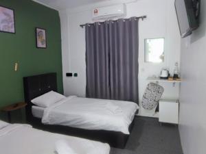 a small room with two beds and a window at Green Forest Resort in Setiu +32 photos