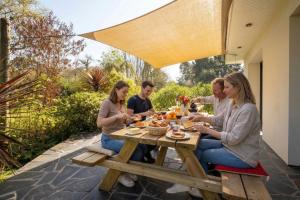 a group of people sitting around a picnic table at EDEN LOCQUIREC l Flow Breathe & SPA l La Chambre d'Hôtes réinventée in Locquirec