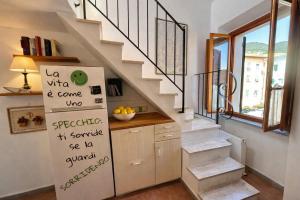 a kitchen with stairs and a refrigerator with writing on it at Borgo & Terrazza - Le Case di Rio in Rio nellʼElba