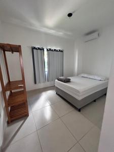 a white bedroom with a bed and a window at Casa Prado in Prado