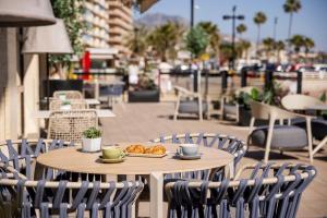 a table and chairs with a tray of pastries on it at Ilunion Fuengirola in Fuengirola