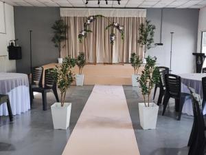 a room with tables and chairs and potted plants at Green Forest Resort in Setiu