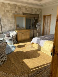 ein Schlafzimmer mit einem Bett, einer Kommode und einem Spiegel in der Unterkunft Oak Chalet in Umm al Manābī‘