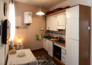 a small kitchen with white cabinets and a white refrigerator at Tuscan retreat in Orciatico