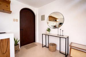 a hallway with a round mirror and a table at Villa Adela Siargao in General Luna