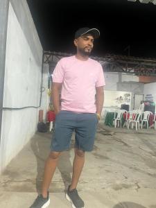 a man wearing a pink shirt and shorts and a hat at DK eventos in Teresina
