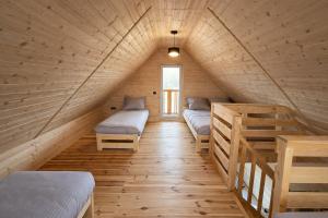 a room with three beds in a wooden house at Noclegi Przy Karczmie in Makowiec