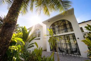 a house with a palm tree in front of it at Villa Adela Siargao in General Luna