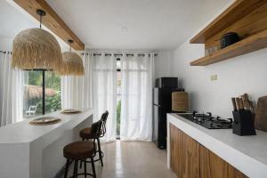 a kitchen with a stove and a counter with chairs at Villa Adela Siargao in General Luna +9 photos