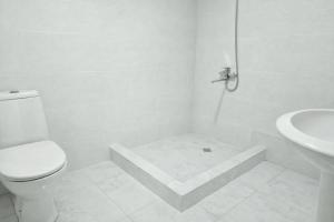 a white bathroom with a toilet and a sink at Kaghu in Martvili +27 photos