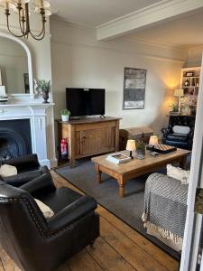 a living room with a couch and a tv at Barley House, Sea and Beach Facing Accommodation in Southwold