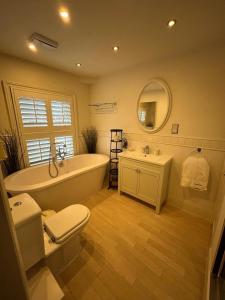 a bathroom with a tub and a toilet and a sink at Barley House, Sea and Beach Facing Accommodation in Southwold +42 photos