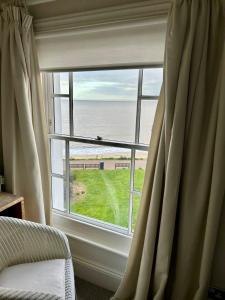 a large window with a view of the ocean at Barley House, Sea and Beach Facing Accommodation in Southwold
