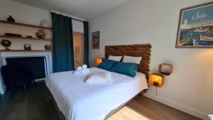 a bedroom with a large white bed with blue pillows at Les Gîtes de Monte Blanco - Domaine avec chambres d'hôtes et gîtes in Montblanc +23 photos