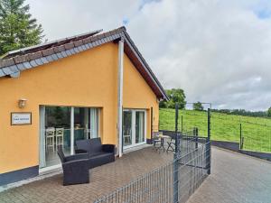 a house with a patio with chairs and a fence at Haus Eifelsonne in Ramscheid