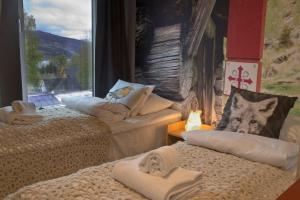 a room with two beds with a wolf pillow at Lillehammer City Hostel in Lillehammer