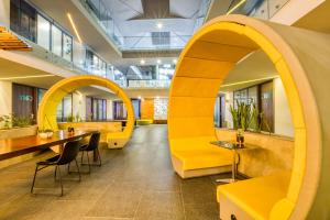 an archway in a restaurant with yellow chairs and tables at Eazy Rio by ULIV in Tijuana +9 photos
