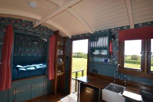 a kitchen with a sink and a bed in a room at Charlotte-Rose Shepherd's Hut in Hethersett
