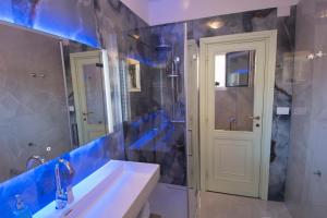 a bathroom with a sink and a shower and a mirror at Anthyllis Apartment in Alghero +38 photos
