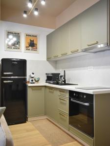 a kitchen with green cabinets and a black refrigerator at Montewave Studio Apartment in Boreti