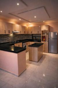 a large kitchen with wooden cabinets and stainless steel appliances at Chez BABAYO BY DADES in Zaouïet Sidi Daoud