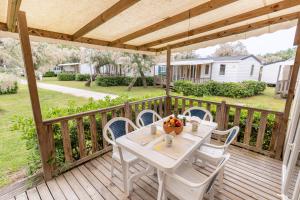 a white table and chairs on a wooden deck at Club del Sole Vigna sul Mar Family Collection in Lido di Pomposa