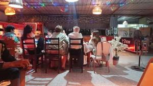 a group of people sitting at a table in a restaurant at Cloud9 Lomé in Lomé
