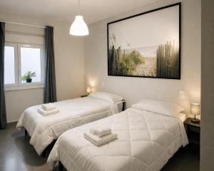 two beds in a room with a picture on the wall at Nova Suites Viveiro in Viveiro