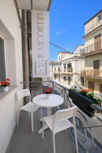 a balcony with a white table and chairs on a building at Il Vicoletto B&B - In pieno centro in Cirò Marina