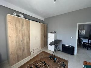a kitchen with a large wooden cabinet in a room at Garden Vila Apartment in Kamëz +1 photo