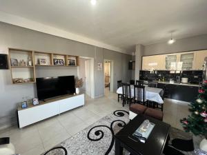 a living room with a christmas tree and a kitchen at Garden Vila Apartment in Kamëz
