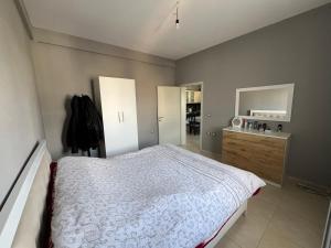 a bedroom with a bed and a dresser and mirror at Garden Vila Apartment in Kamëz