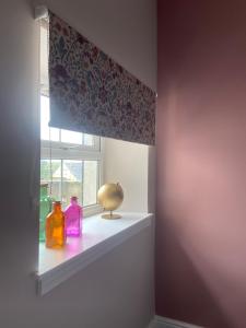 a window with two bottles on a window sill at Warm Spacious apartment in Pembroke Dock