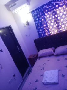 a bedroom with a bed and a purple room at Primenest Executive Suites in Gwagwalada